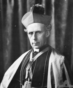 Archbishop Daniel Mannix wearing a four-cornered hat, cape and elaborate insignia of office around his neck.